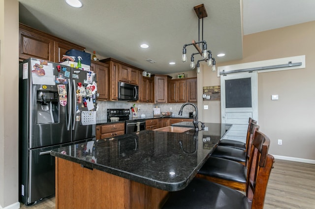 kitchen with range with electric cooktop, baseboards, light wood-type flooring, stainless steel fridge, and backsplash