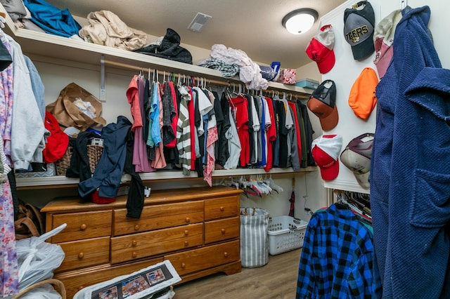 walk in closet with visible vents and wood finished floors