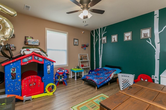 bedroom with wood finished floors, visible vents, and a ceiling fan