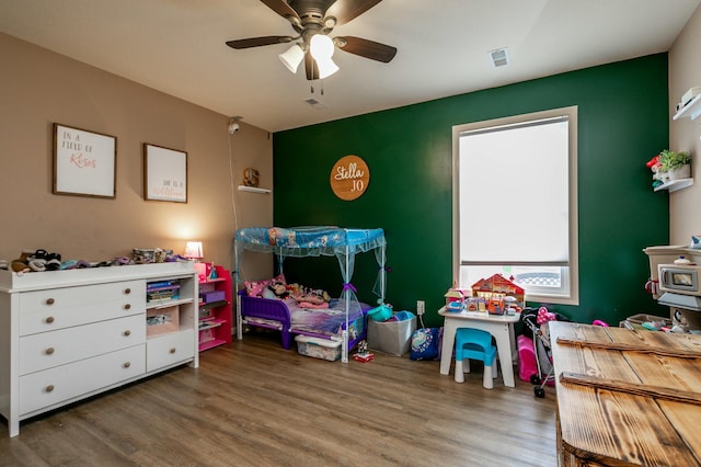 bedroom featuring wood finished floors, ceiling fan, and visible vents