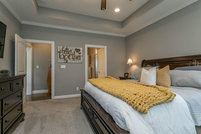 bedroom with light colored carpet, a raised ceiling, ornamental molding, and baseboards