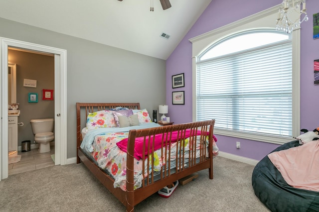 carpeted bedroom featuring visible vents, vaulted ceiling, multiple windows, and ensuite bath