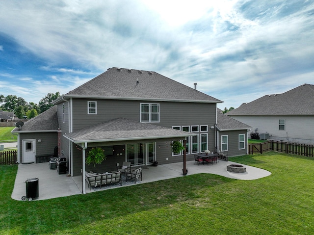 rear view of house featuring a yard, a fire pit, fence, a patio area, and roof with shingles