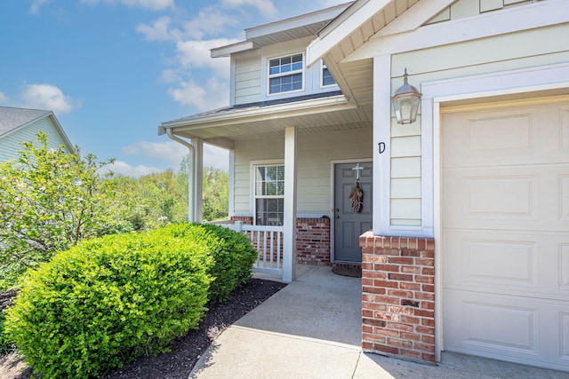 doorway to property with covered porch and brick siding