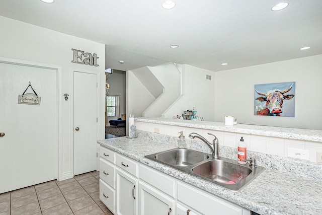 kitchen with white cabinetry, a sink, light countertops, recessed lighting, and light tile patterned flooring