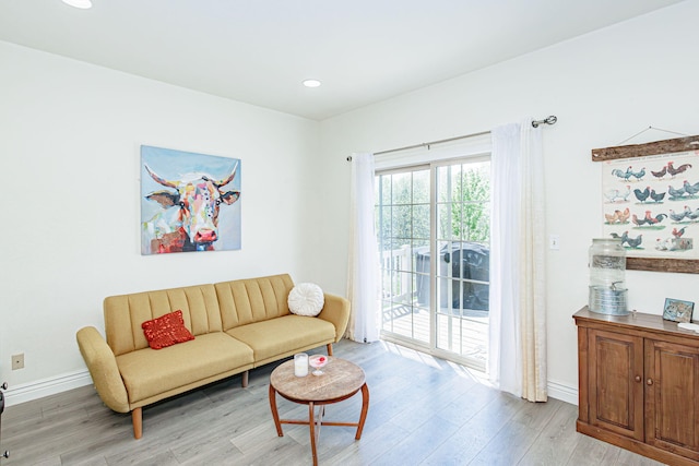 living area featuring recessed lighting, baseboards, and light wood-type flooring
