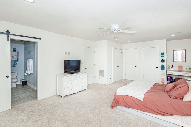 bedroom featuring visible vents, two closets, light carpet, recessed lighting, and connected bathroom