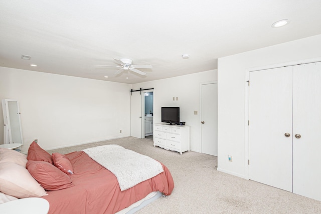 bedroom featuring recessed lighting, a barn door, a ceiling fan, and light carpet