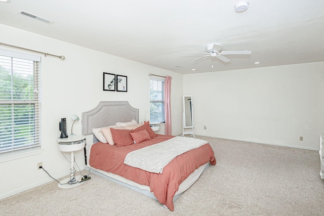 bedroom featuring carpet floors, visible vents, and multiple windows