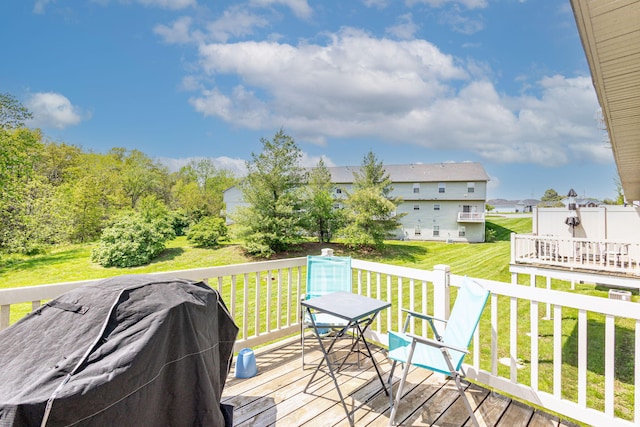 deck with a lawn, outdoor dining space, a residential view, and a grill