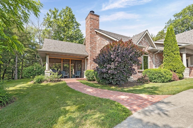 7114 W River Oaks Rd, Columbia, MO 65203 - view of front of house featuring a front lawn, roof with shingles, a chimney, and brick siding