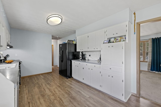 208 Bourn Ave, Columbia, MO 65203 - kitchen with black fridge with ice dispenser, light wood-style flooring, decorative backsplash, white cabinets, and baseboards