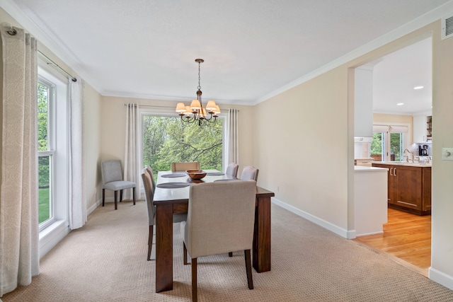 dining room featuring a notable chandelier, baseboards, and a healthy amount of sunlight