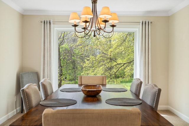 carpeted dining area featuring an inviting chandelier, plenty of natural light, ornamental molding, and baseboards