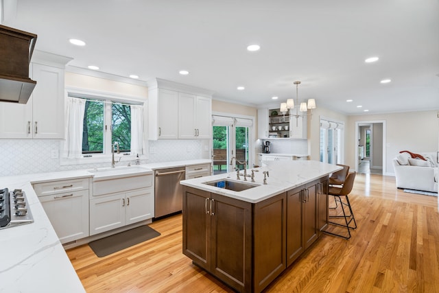 kitchen with white cabinetry, an island with sink, appliances with stainless steel finishes, and a sink