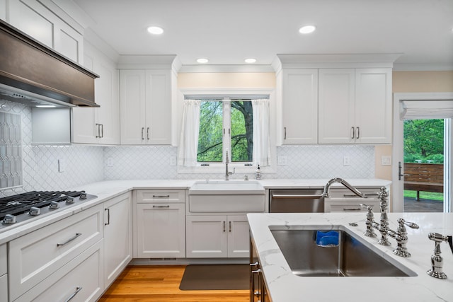 kitchen with appliances with stainless steel finishes, plenty of natural light, extractor fan, and a sink