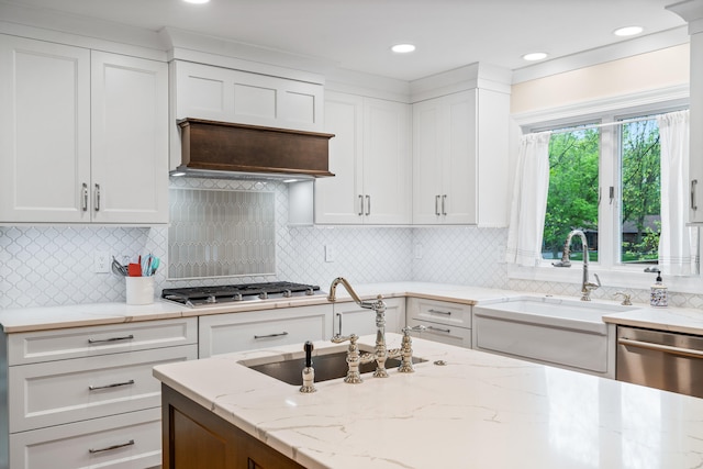 kitchen featuring appliances with stainless steel finishes, white cabinets, and a sink