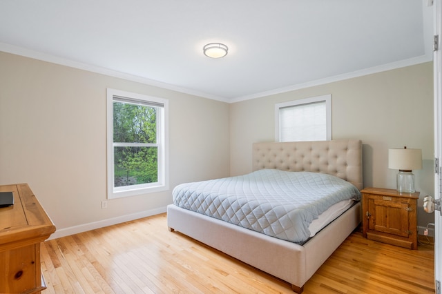 bedroom featuring crown molding, baseboards, and light wood-style floors