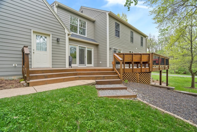 rear view of house with a wooden deck and a yard