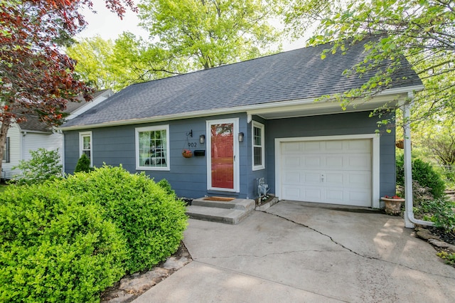 single story home featuring roof with shingles, an attached garage, and concrete driveway