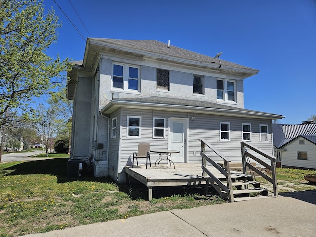 back of property featuring a deck, a yard, and central AC