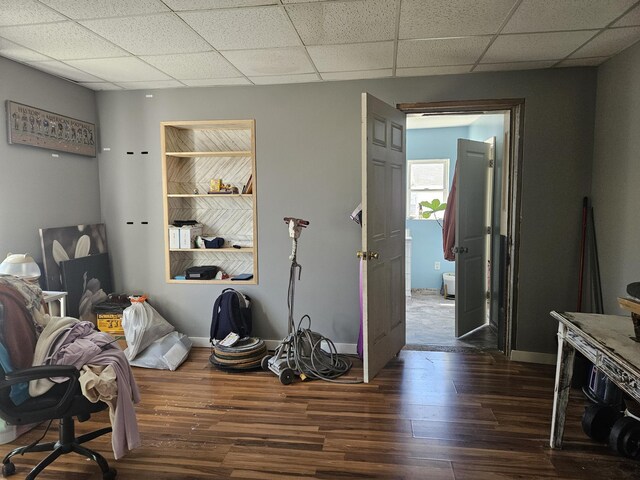 miscellaneous room featuring a paneled ceiling, dark wood finished floors, and baseboards