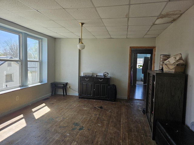 dining space with a paneled ceiling, dark wood finished floors, and baseboards