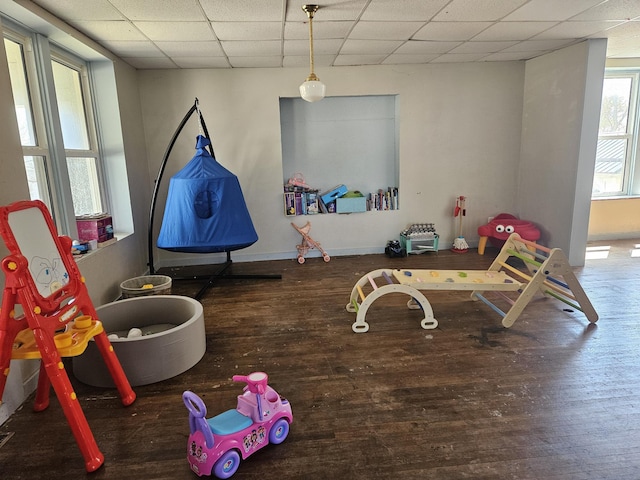 recreation room with a paneled ceiling and wood finished floors