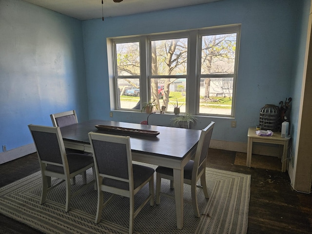 dining space with baseboards, wood finished floors, and plenty of natural light