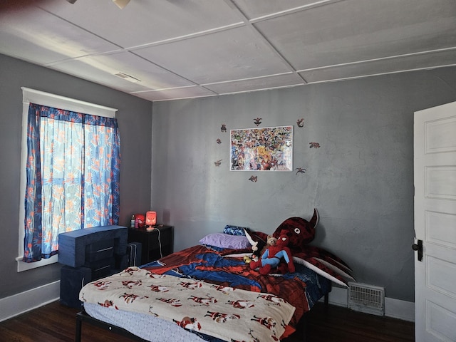 bedroom with visible vents, wood finished floors, and baseboards