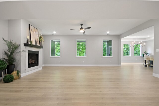 6176 Partridge Ct, Columbia, MO 65202 - unfurnished living room featuring a chandelier, a fireplace, light wood finished floors, healthy amount of natural light, and recessed lighting