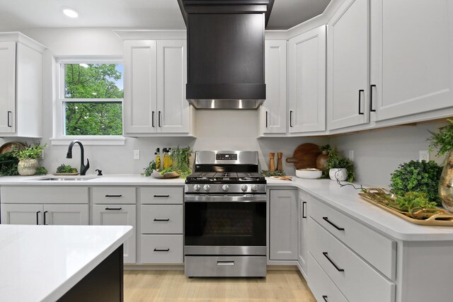 6176 Partridge Ct, Columbia, MO 65202 - kitchen featuring stainless steel gas range oven, range hood, light countertops, white cabinets, and recessed lighting