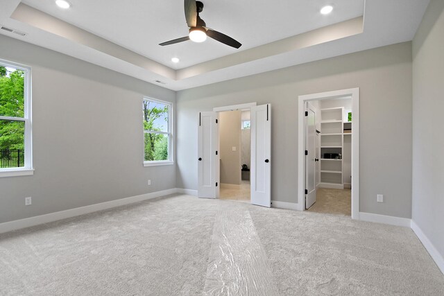 6176 Partridge Ct, Columbia, MO 65202 - unfurnished bedroom featuring light colored carpet, multiple windows, a raised ceiling, a spacious closet, and recessed lighting