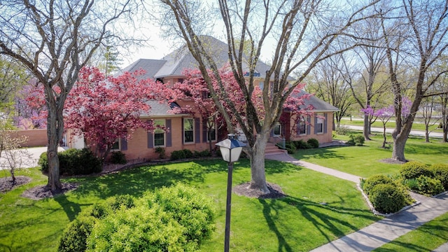 view of front of home with roof with shingles and a front lawn