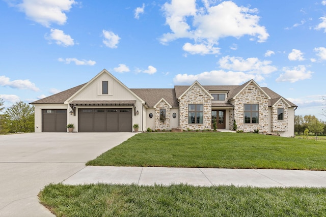 view of front of house with a front lawn, driveway, an attached garage, and stone siding