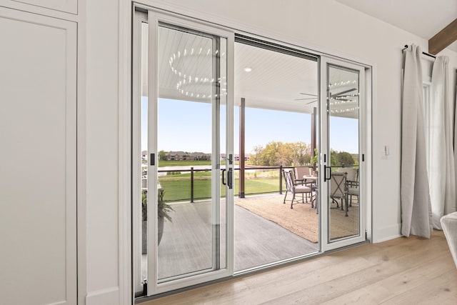 doorway to outside featuring baseboards and light wood-type flooring