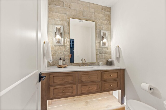 bathroom featuring vanity, toilet, and visible vents