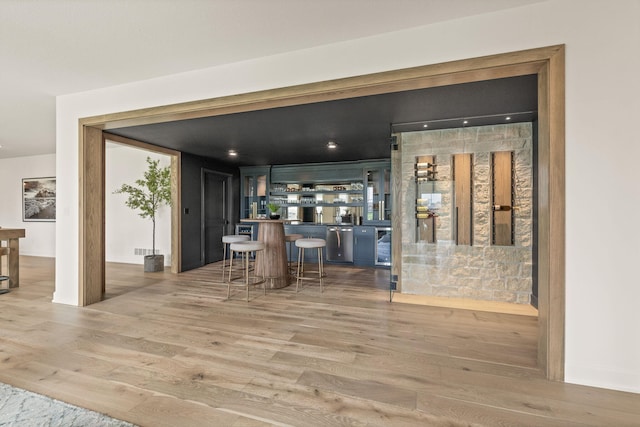 bar featuring visible vents, light wood-type flooring, and bar