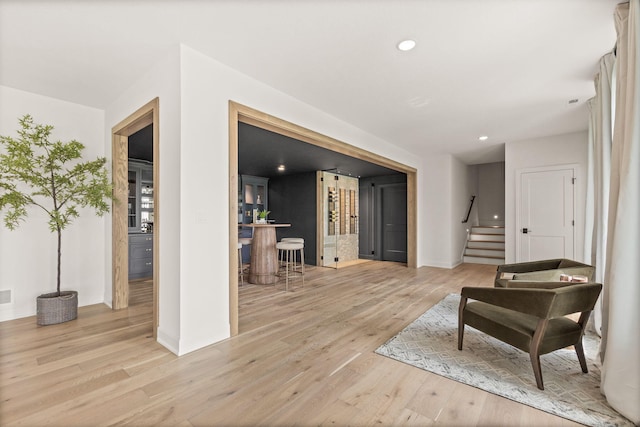 living area featuring recessed lighting, light wood-style floors, stairs, visible vents, and baseboards
