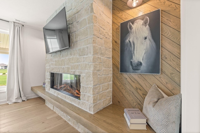 living area featuring a fireplace, wood finished floors, and baseboards