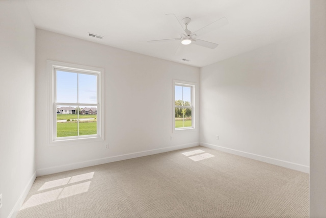 unfurnished room featuring visible vents, baseboards, and light carpet