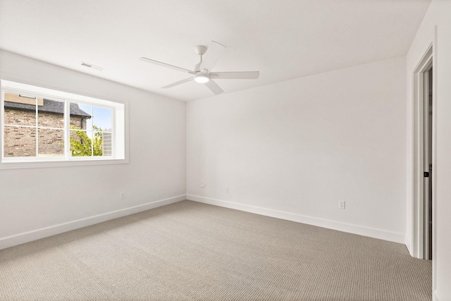 carpeted empty room featuring visible vents, ceiling fan, and baseboards