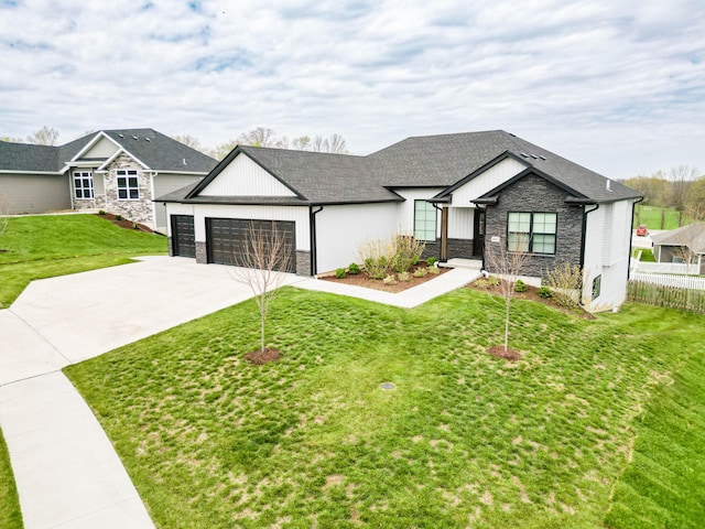 view of front of home featuring concrete driveway, board and batten siding, stone siding, a front lawn, and a garage
