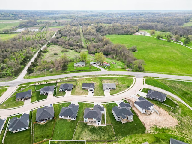 drone / aerial view with a wooded view and a residential view