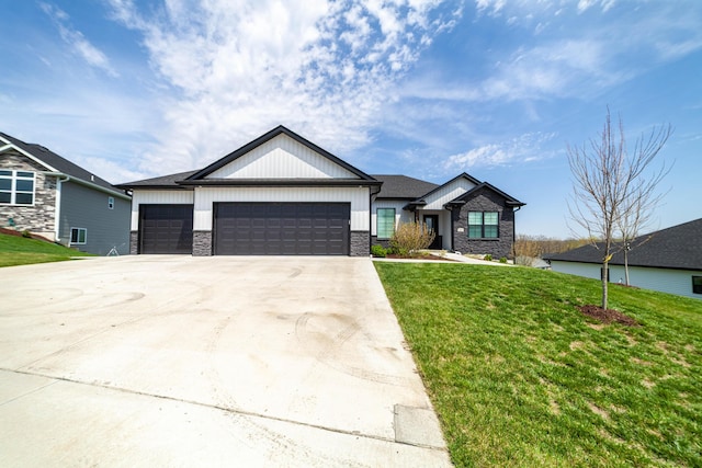 view of front facade featuring driveway, board and batten siding, stone siding, a front lawn, and a garage