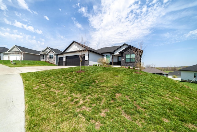 view of front facade with a front lawn, concrete driveway, an attached garage, and stone siding