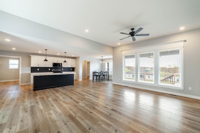 living area featuring recessed lighting, light wood-style flooring, and baseboards