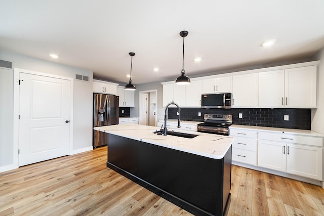 kitchen featuring stainless steel appliances, white cabinets, backsplash, a sink, and visible vents