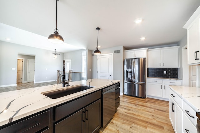 kitchen featuring appliances with stainless steel finishes, visible vents, white cabinetry, and a sink