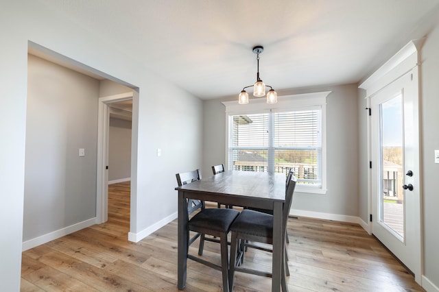 dining space with baseboards and light wood finished floors